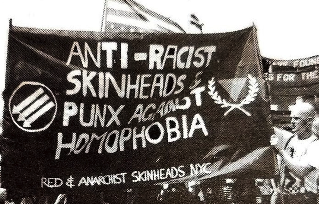 Photo from a New York City R.A.S.H. march depicting a banner with the three arrows and a pink triangle.